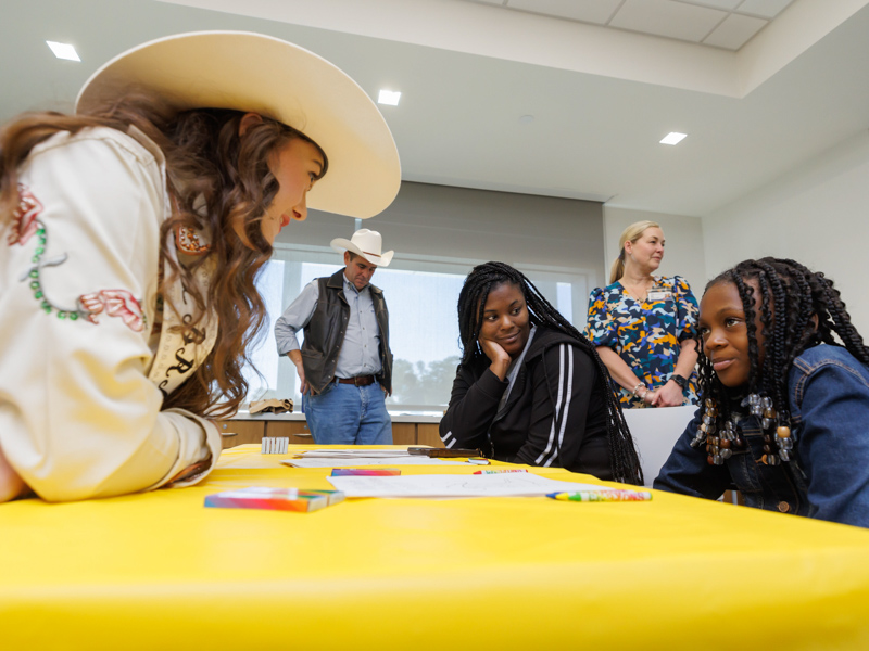 Mid-South Little Britches Rodeo Association Queen Josi Johnson visits with Children's of Mississippi patient Tasia Freeman of Vicksburg as mom Shanequia Montgomery looks on.